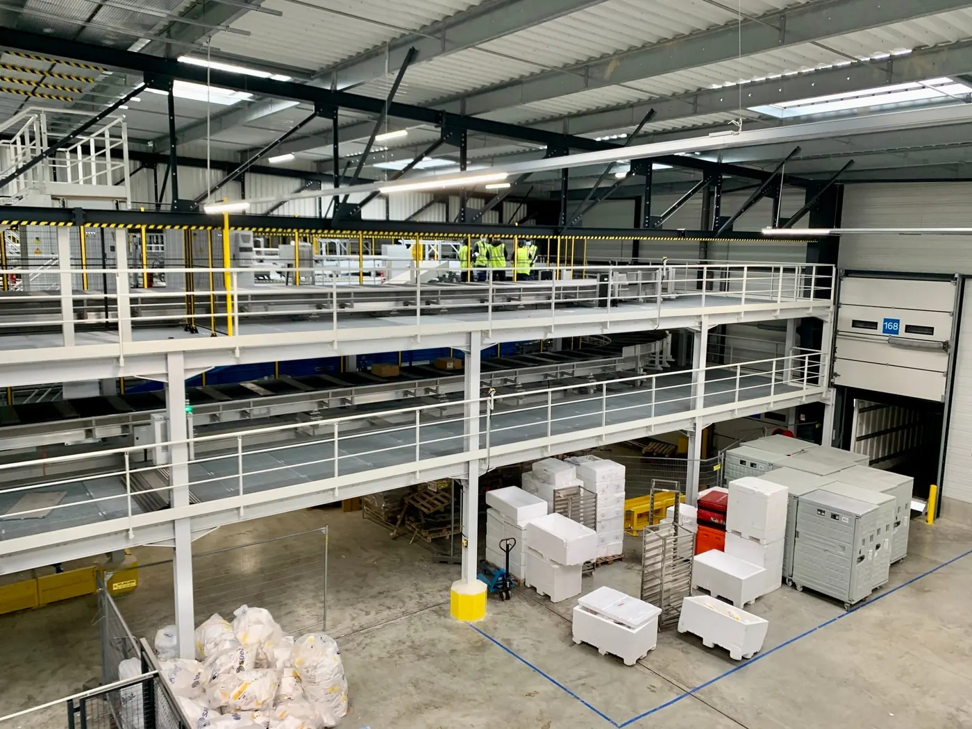 Mezzanine with a grating deck, several staircases and guardrails in an industrial building