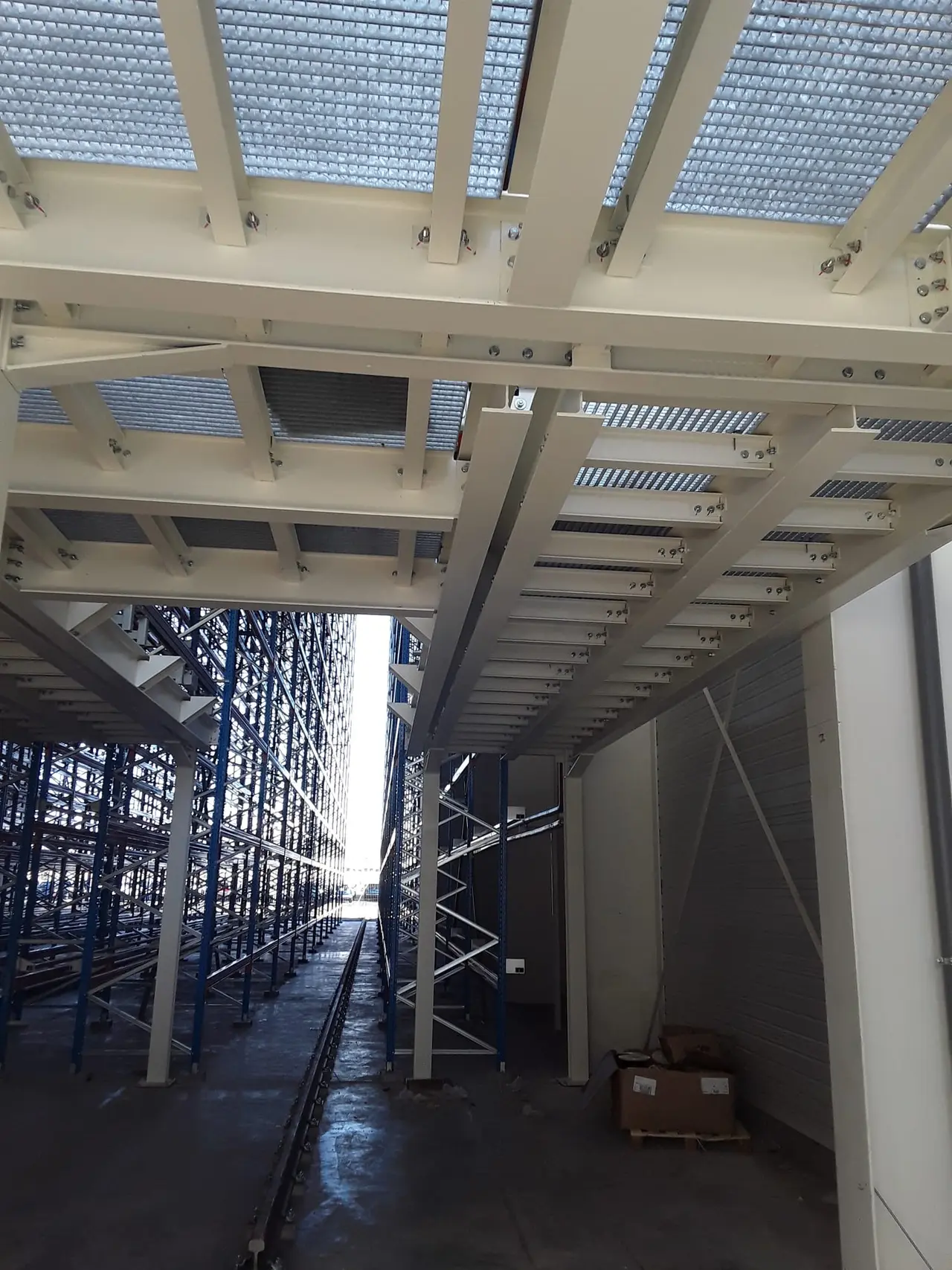 Storage mezzanine alongside high-bay racking