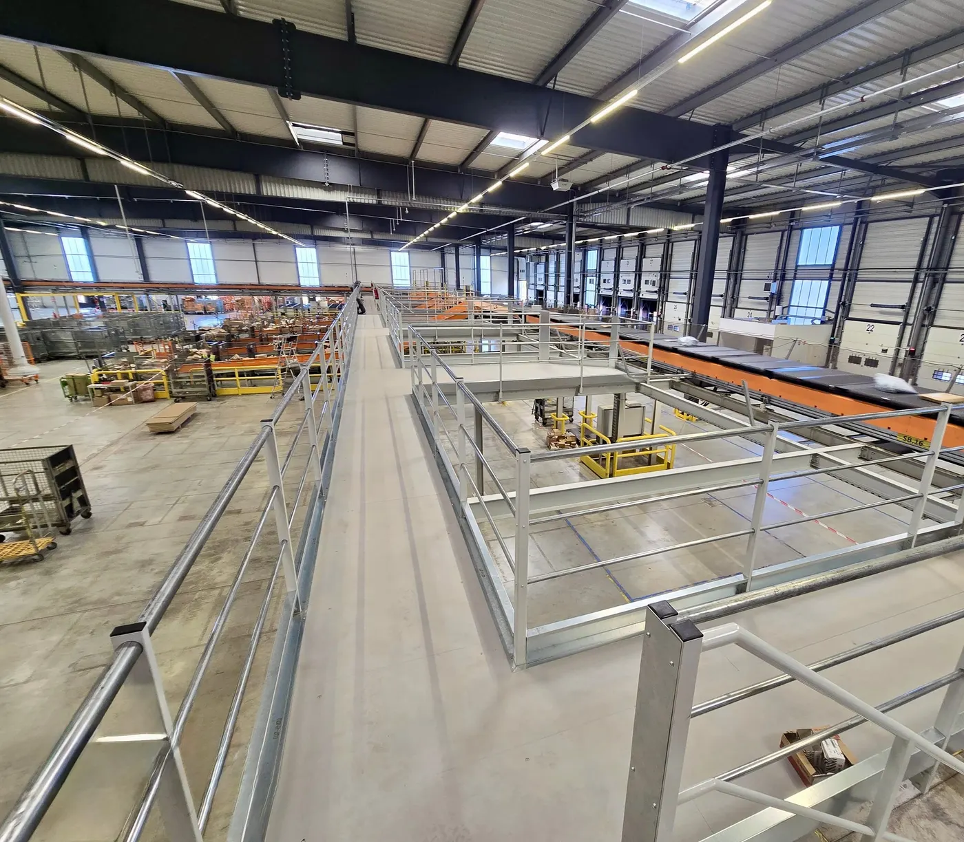 Mezzanine walkway with guardrails overlooking the order-picking area of a warehouse