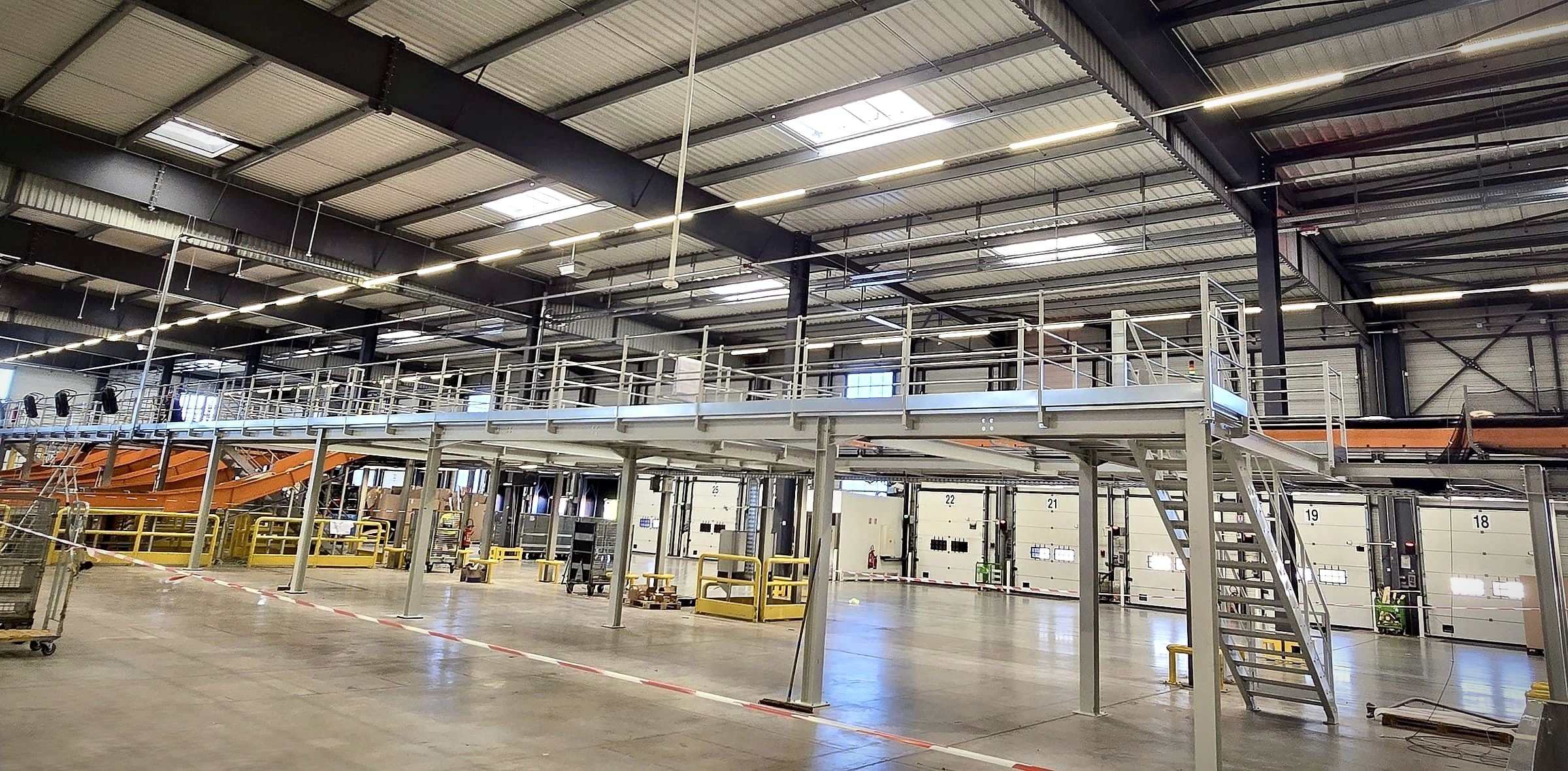 Grande plateforme logistique TDEM3 avec garde-corps et escaliers sur toute la longueur d'un entrepôt