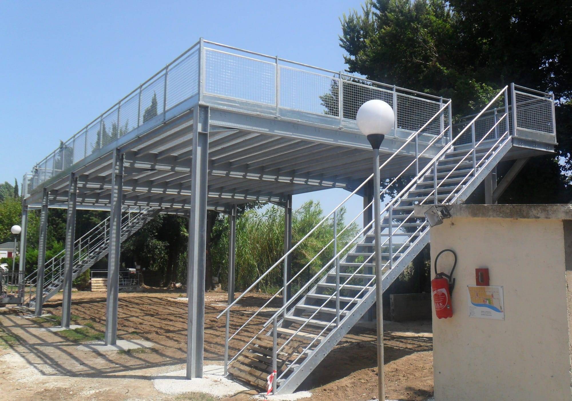 Steel flood refuge platform with access stairs on a campsite